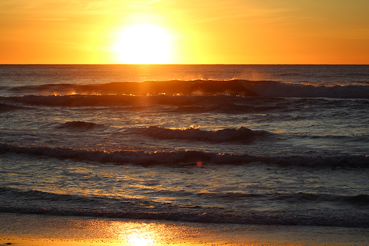Sunrise over ocean waves